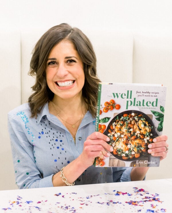 Well Plated Cookbook Author Erin Clarke holding The Well Plated Cookbook