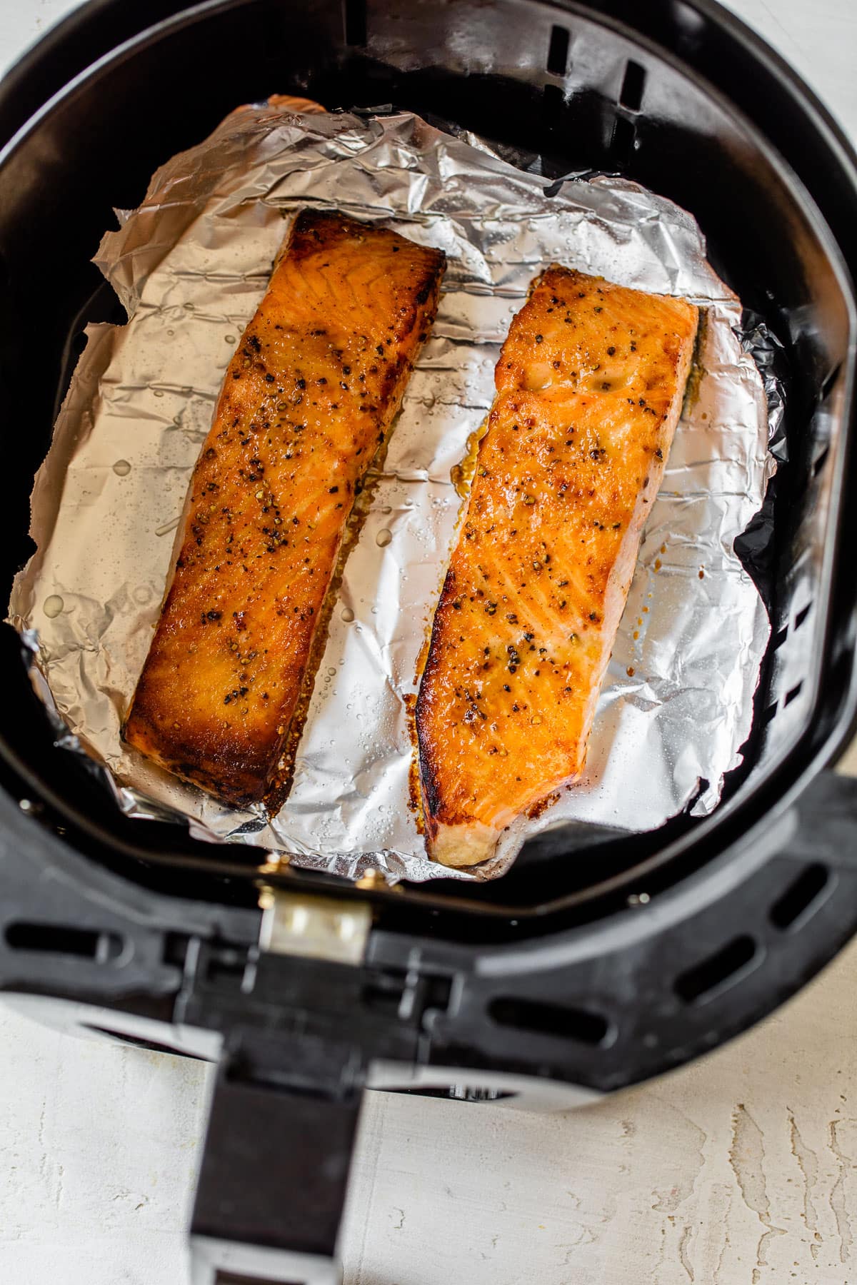 Two salmon fillets in an air fryer