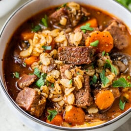 Beef barley soup with carrots in a bowl