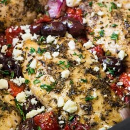 slow cooker Greek chicken topped with kalamata olives, fresh herbs, and feta cheese