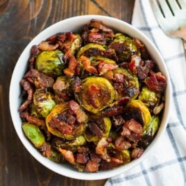a bowl with roasted maple bacon brussels sprouts with bacon pieces on top