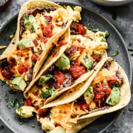 three easy breakfast tacos with toppings on a plate