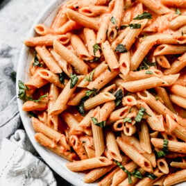 the best penne alla vodka on a plate with herbs