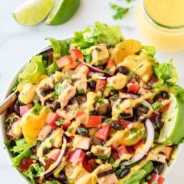 Grilled Caribbean Chicken Salad with 5 Minute Mango Dressing. WAY better than your favorite restaurant salad at a fraction of the cost! Packed with juicy chicken, crunchy veggies, black beans, and the best tangy mango dressing! @wellplated