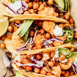Crispy Cauliflower Tacos with chickpeas topped with avocado, jalapeno, and red cabbage