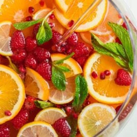 A glass bowl of champagne punch with fruit