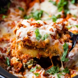 Crockpot lasagna being scooped out of a slow cooker