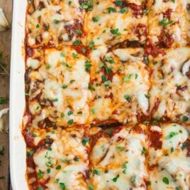 A pan of no noodle Classic Eggplant Lasagna made with roasted eggplant, mushrooms, ricotta, and topped with Mozzarella cheese and fresh herbs.