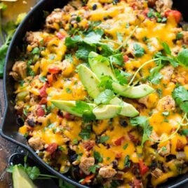 One Pan Cheesy Fiesta Chicken and Rice. Easy, healthy recipe that is PACKED with southwest ranch flavor! Juicy chicken, fresh veggies, and tender brown rice, cooked with a delicious blend of spices. If you like Mexican food, you will LOVE this recipe! #casserole #healthy #easy #fiestachicken