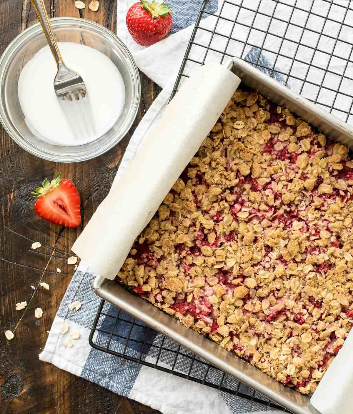 Strawberry Crumb Bars recipe — with a buttery crust, sweet fresh strawberry filling, butter crumb topping, and vanilla glaze, these bars have it all and are so easy! Made with 100% whole grain and the natural sweetness of strawberries, they are healthy enough for a snack but make a wonderful dessert bar for a party or picnic too! @wellplated