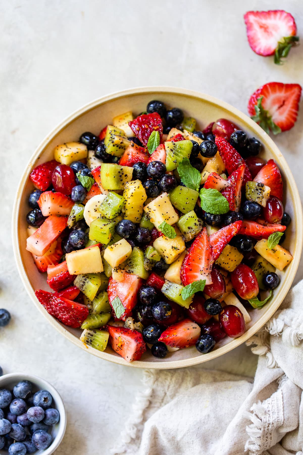 tropical fruit salad in a bowl with poppyseeds