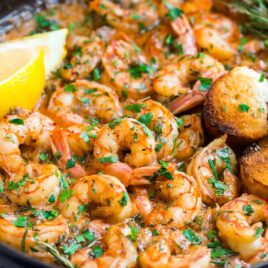 A Skillet of Healthy Garlic Butter Shrimp with Lemon Slices and Rosemary