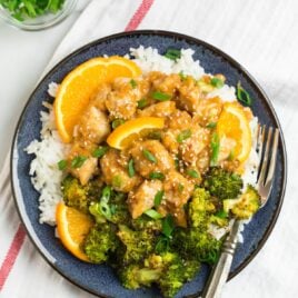Healthy orange chicken with rice and broccoli on a blue plate