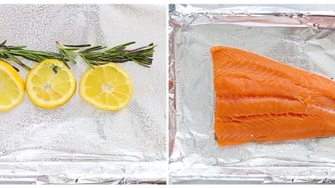 lemons and rosemary on a baking sheet with a salmon fillet