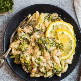creamy cavatelli and broccoli pasta on a white plate with lemon