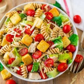 Healthy Chicken Caesar Pasta Salad. DELISH! Fresh, creamy, and packed with fresh veggies and juicy chicken. The dressing is made with Greek yogurt, so it's super creamy but much lighter. Perfect for parties, healthy lunches and dinners, and busy families. Use bowtie pasta or any shape you love.