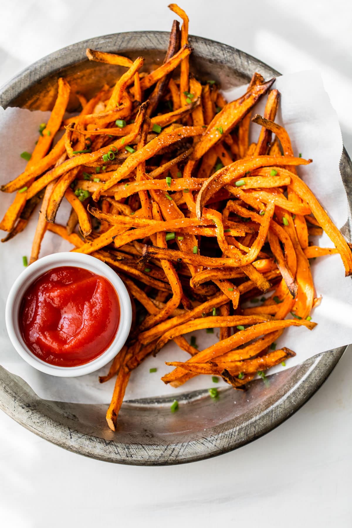Overhead view of crispy air fryer sweet potato fries on plate with ketchup