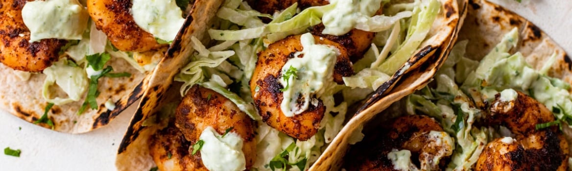 The BEST Healthy Shrimp Tacos with Cilantro Lime Sauce and Cabbage Slaw. Juicy, spicy, and so quick and easy! Cook on the stove or grill!