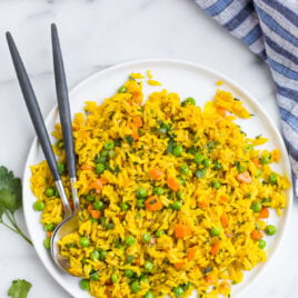 Simple turmeric rice on a plate with two spoons