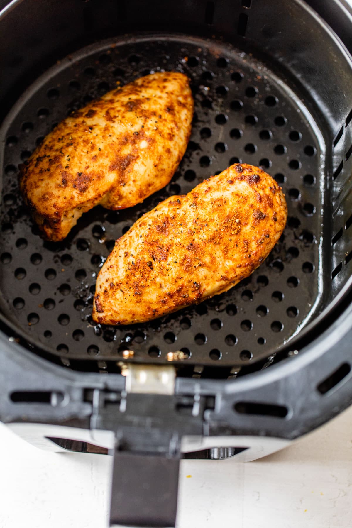 Two chicken breasts in an air fryer