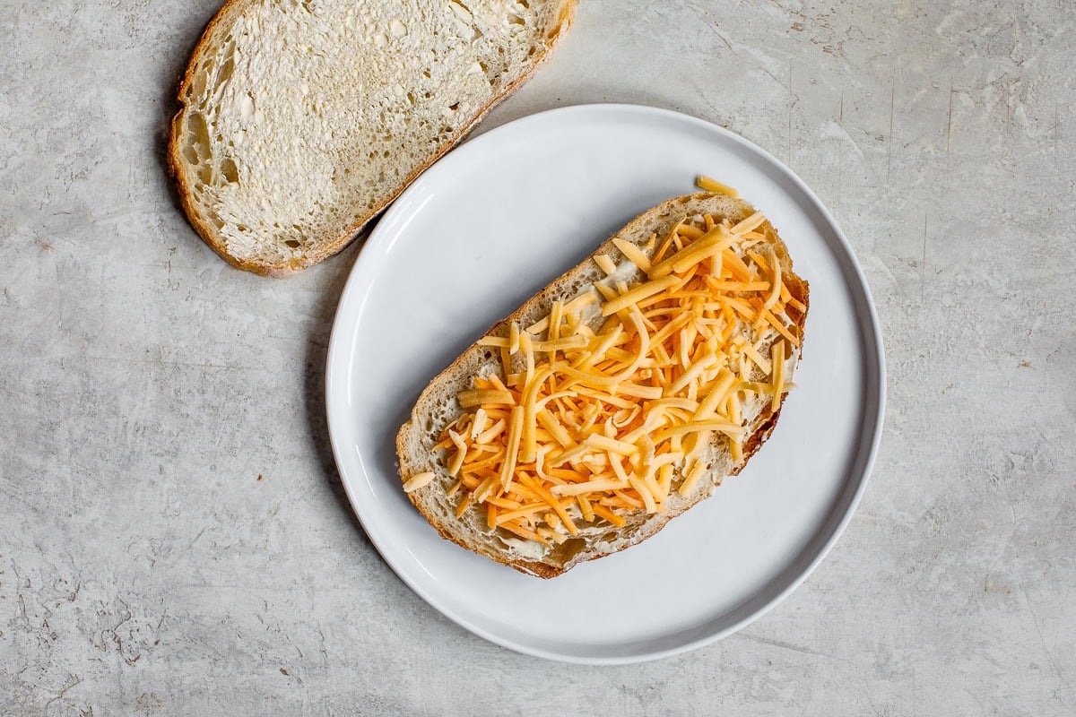 Shredded cheese on a piece of bread