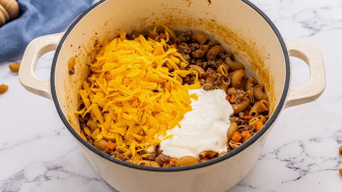 Cheese on top of ingredients in a Dutch oven