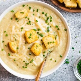 A white bowl with Instant Pot potato soup and croutons