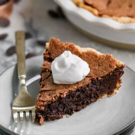 a slice of fudge brownie pie topped with whipped cream