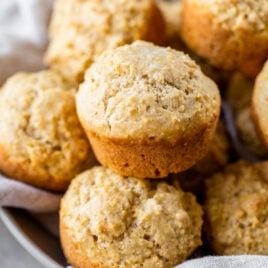 a basket of fluffy and moist cornbread muffins with applesauce