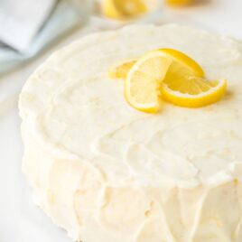 lemon layer cake frosted with lemon cream cheese frosting, garnished with lemon slices