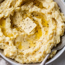 A white bowl with crockpot mashed potatoes