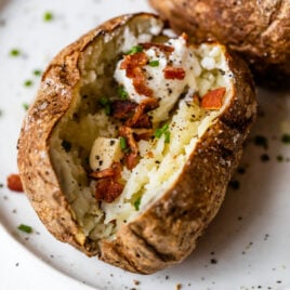 An air fryer baked potato with butter and bacon
