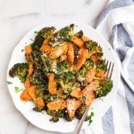 Roasted broccoli and carrots on a plate with Parmesan