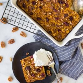 Healthy Pumpkin Baked Oatmeal with dried cranberries, maple syrup, and pecans. No sugar! Super filling and absolutely delicious! Perfect for fall mornings and on-the-go healthy snacks.