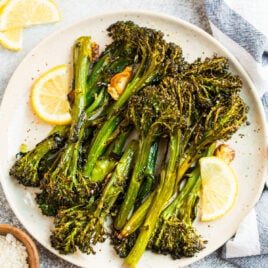 A plate of roasted broccolini with lemons