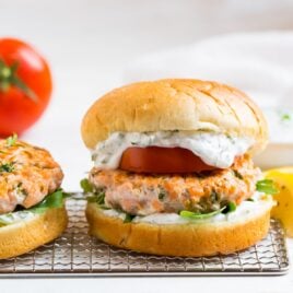 Salmon burgers with tomato, arugula, and sauce
