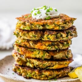 a stack of crispy zucchini fritters on a white plate