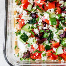 Skinny Greek Layer Dip made with hummus in a glass dish
