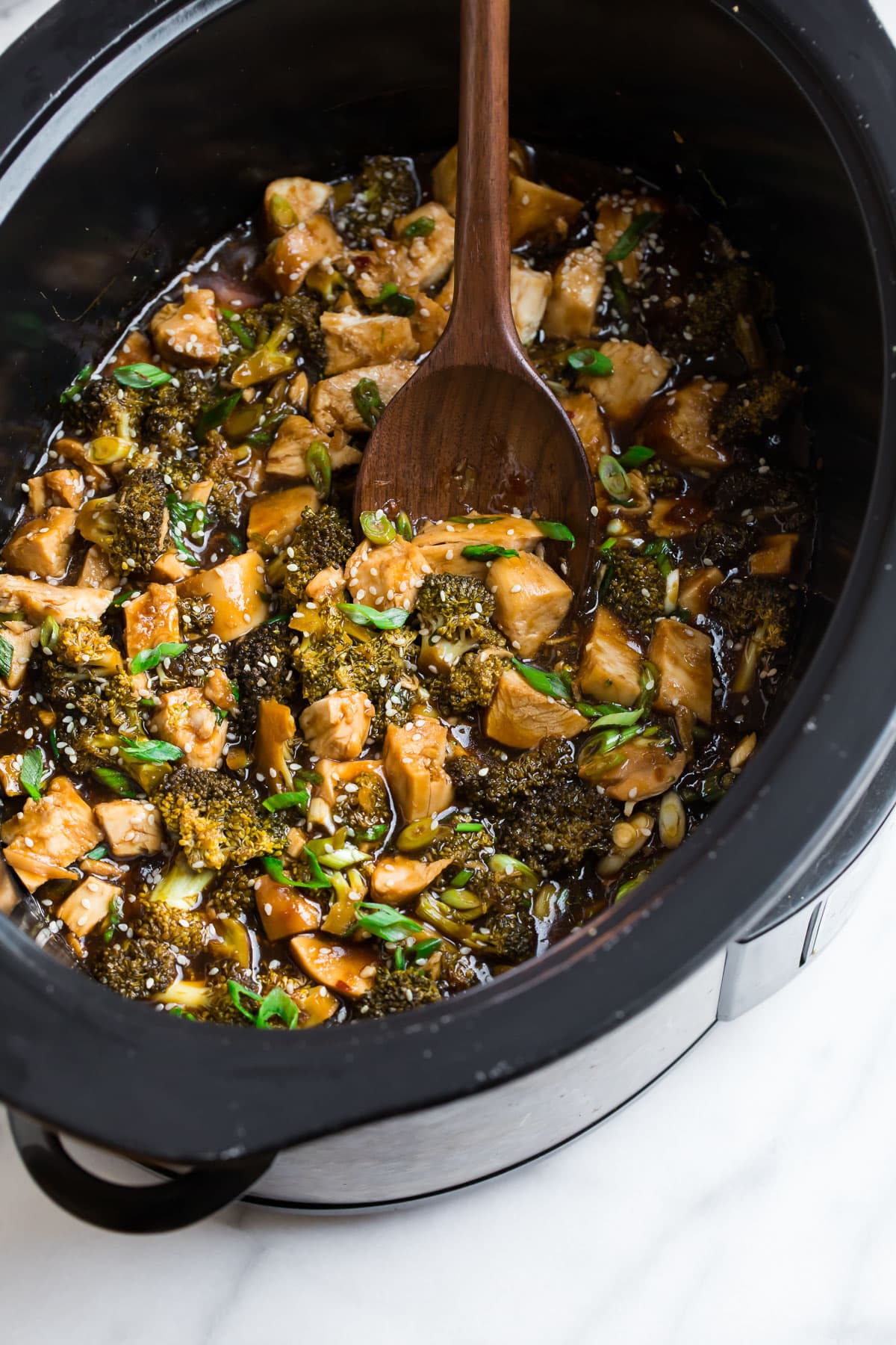 A crockpot filled with chicken and broccoli with a soy ginger sauce