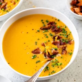 A bowl of Wisconsin potato cheese soup topped with bacon and chives