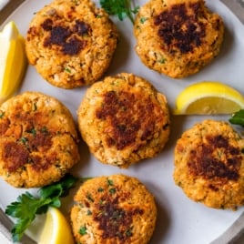 salmon patties on a plate with a slice of lemon