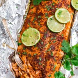 Spicy baked salmon in aluminum foil with lime slices