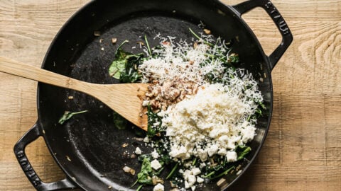 Cheese, walnuts, and spinach in a skillet
