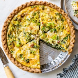 Easy quiche with spinach, cheese, and ham in a store bought pie crust with a slice cut out